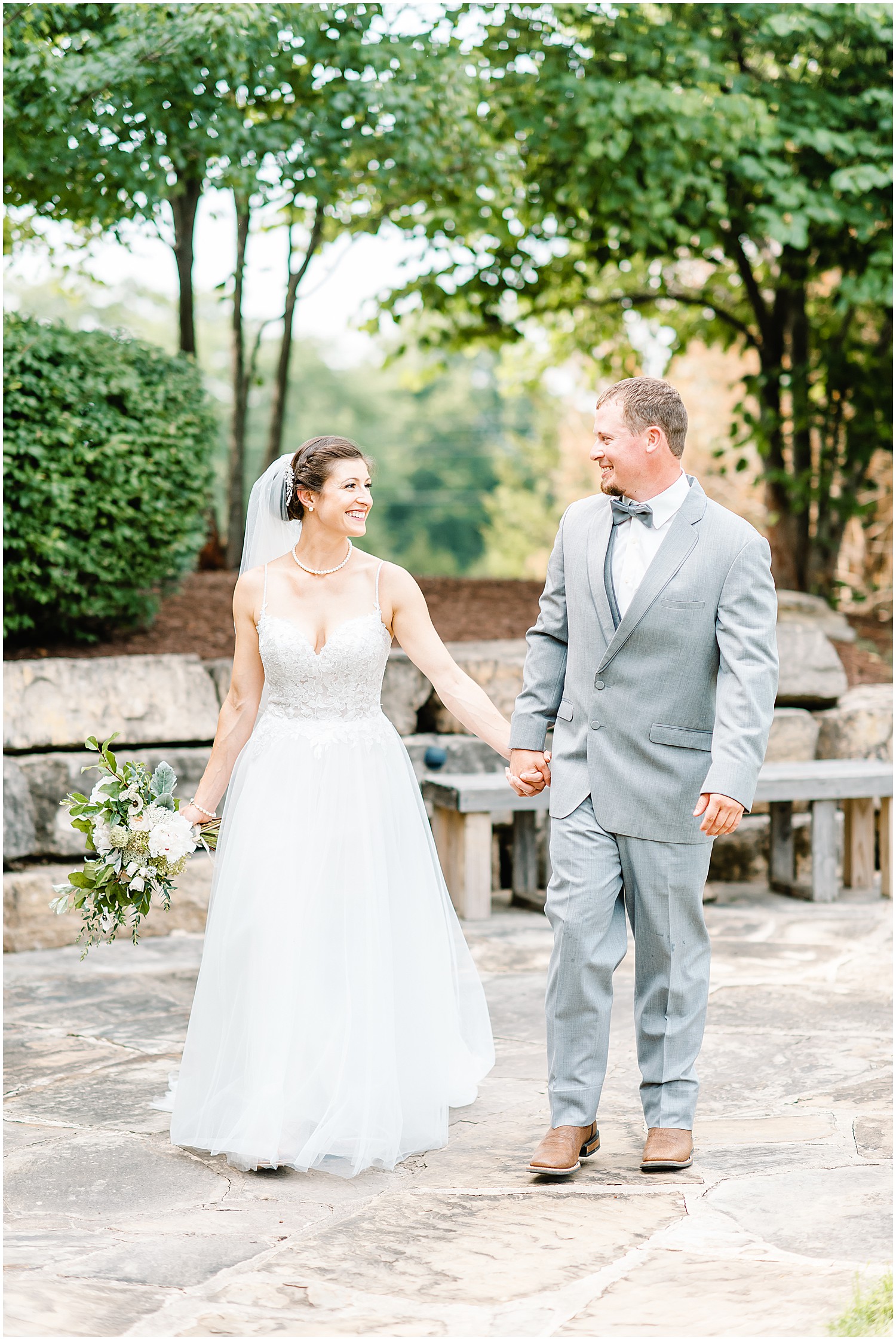 a smiling bride and groom walk hand in hand after their first look on their wedding day at cedar lake cellars