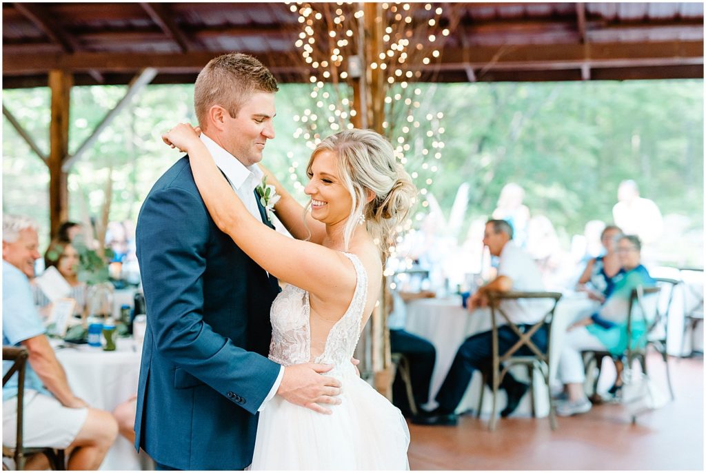 bride and groom first dance under covered patio at little piney lodge 