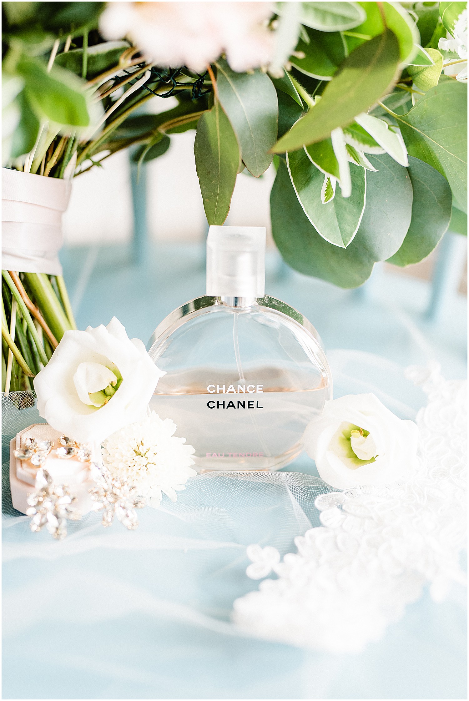 up close image of Chanel perfume with white flowers and green bouquet