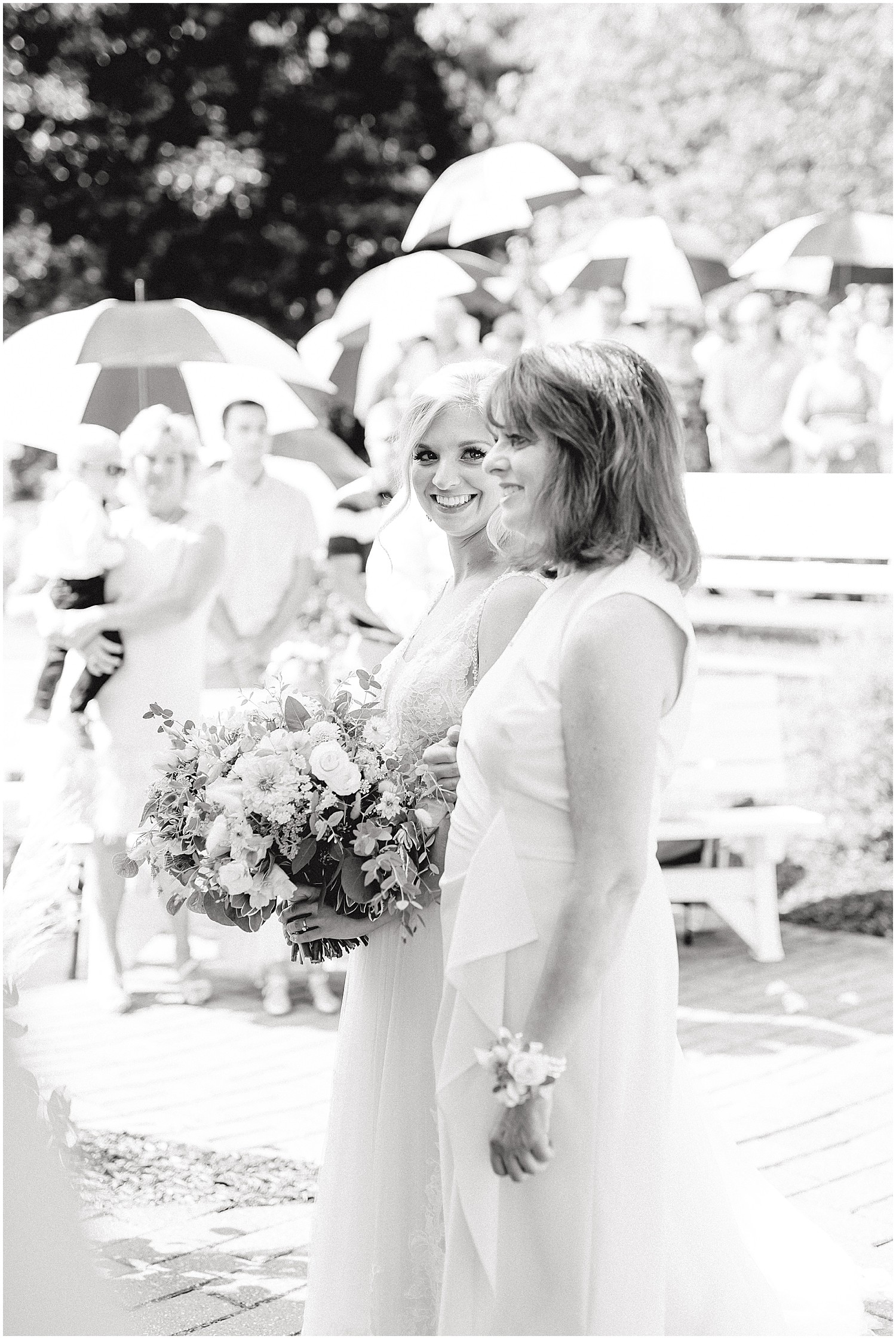 black and white image of bride glancing at her mother during wedding ceremony at little piney lodge in Hermann, mo