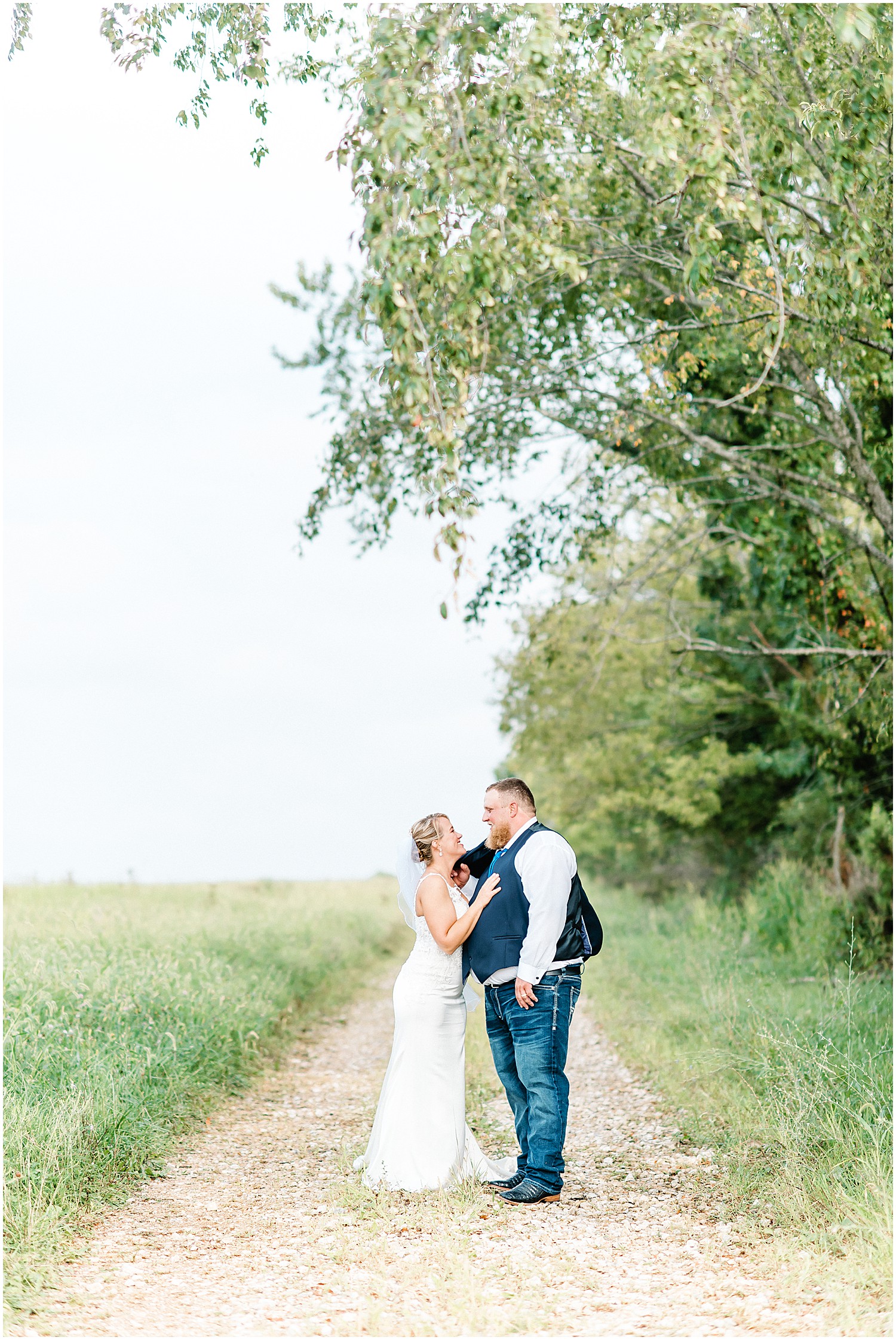 bride and groom holding each other on path during wedding day portraits