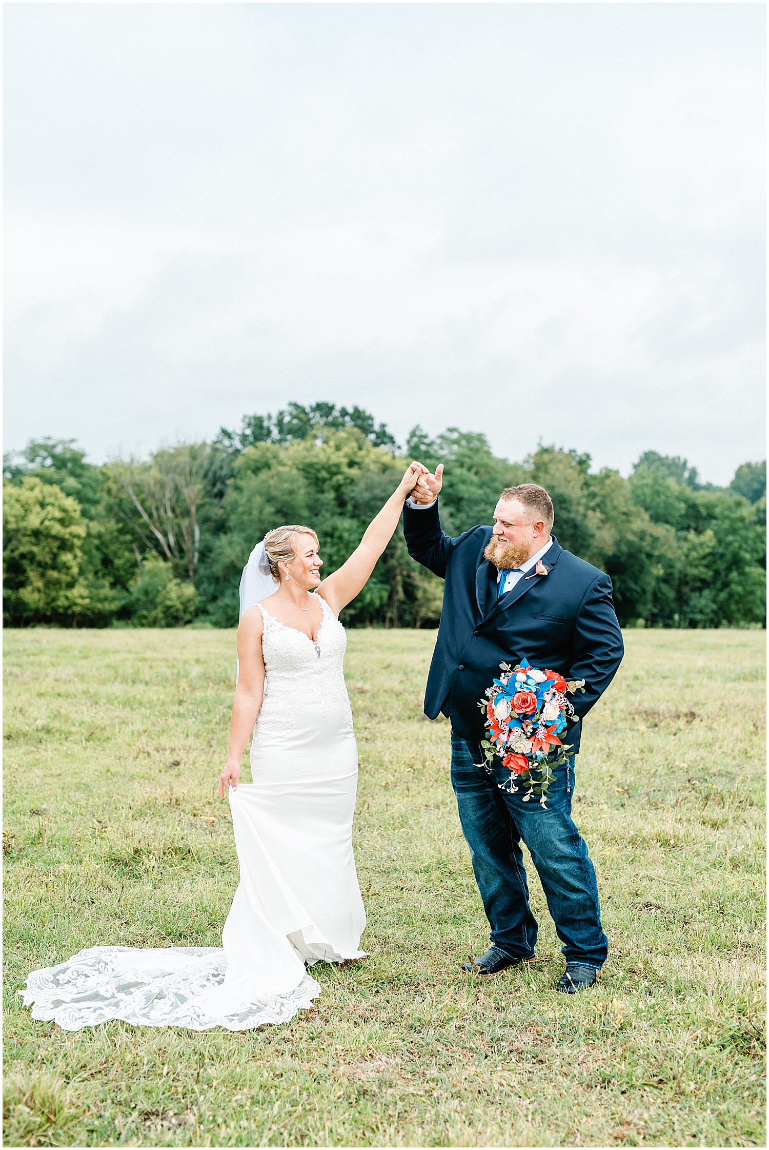 bride and groom dancing in field on wedding day