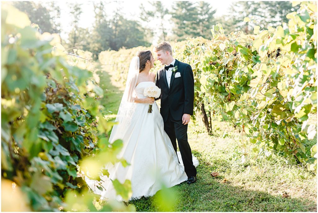 bride and groom smiling at each other in vineyards at les bourgeois winery on wedding day