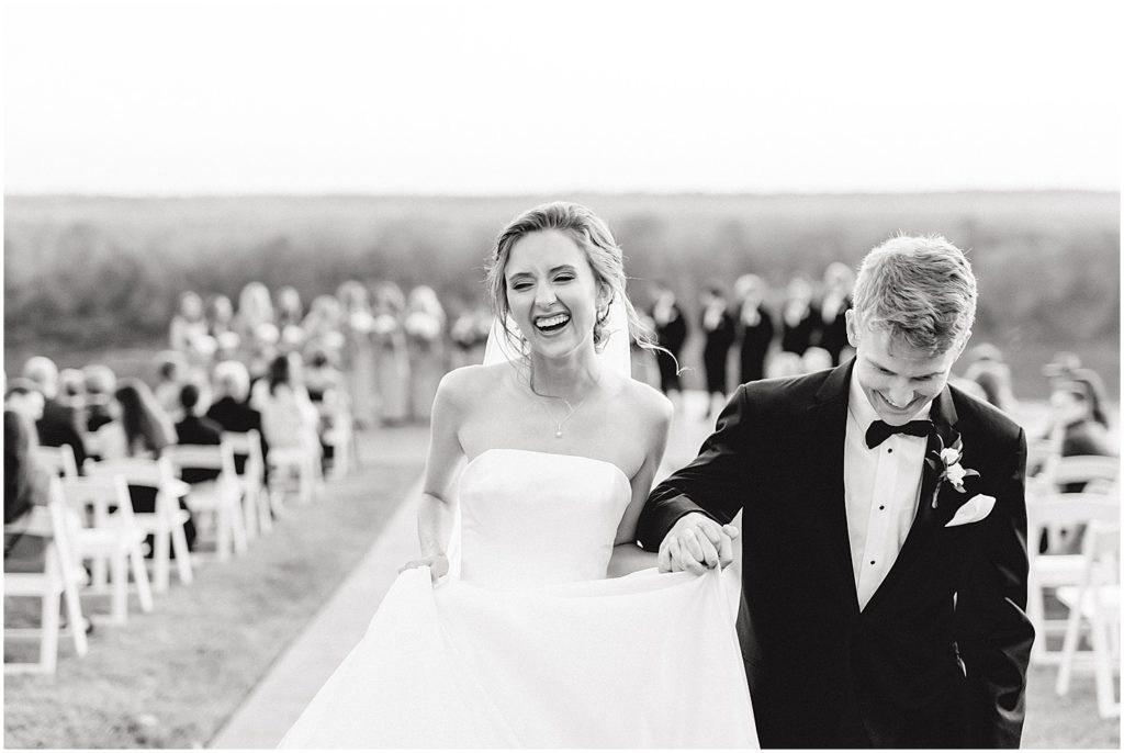 black and white image of bride and groom walking down the aisle after wedding ceremony