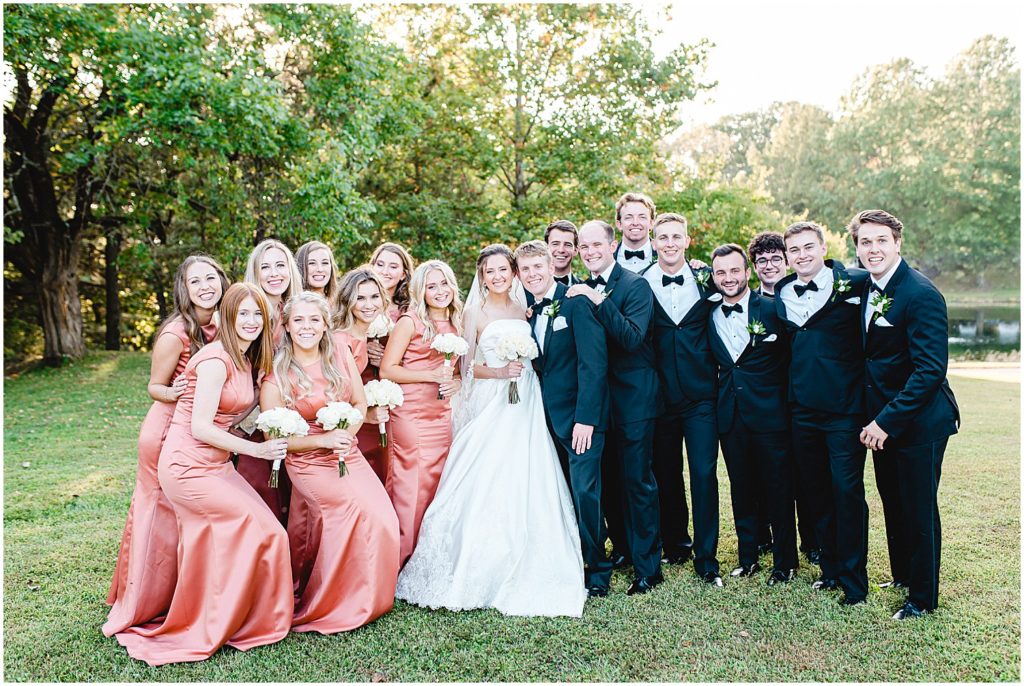 bride and groom surrounded by wedding party during portraits