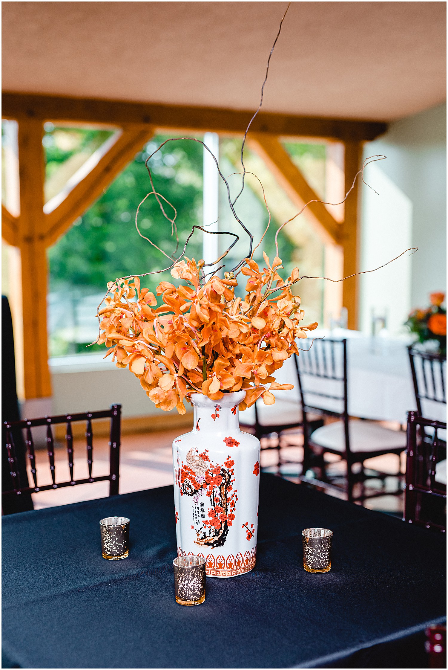 vase with rust colored orchids as centerpiece for fall wedding reception