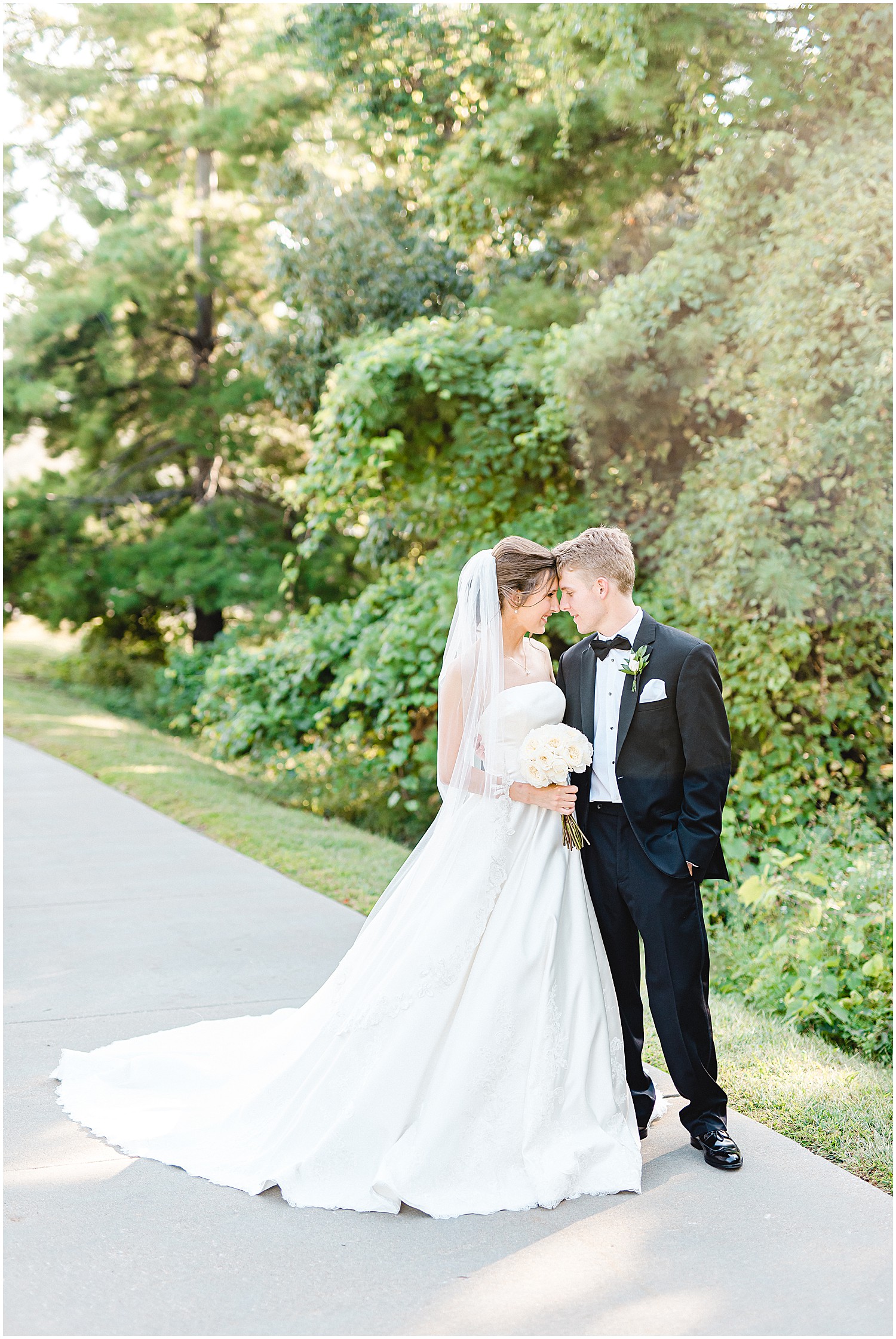 bride and groom portraits on sidewalk in front of trees on wedding day in columbia, mo