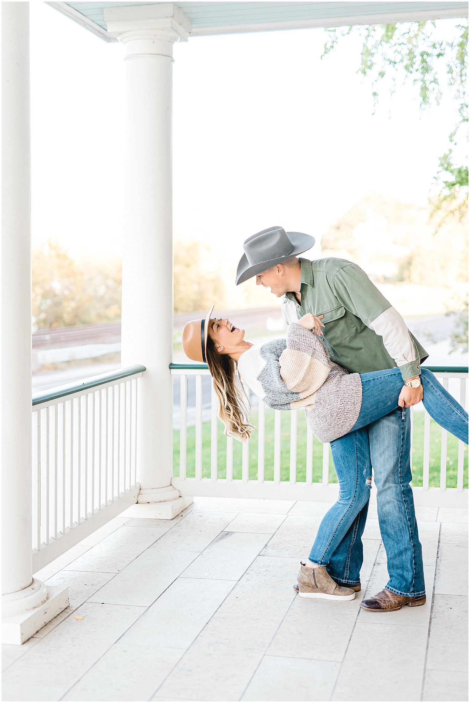 couple laughs on white porch during Hermann Farm engagement session