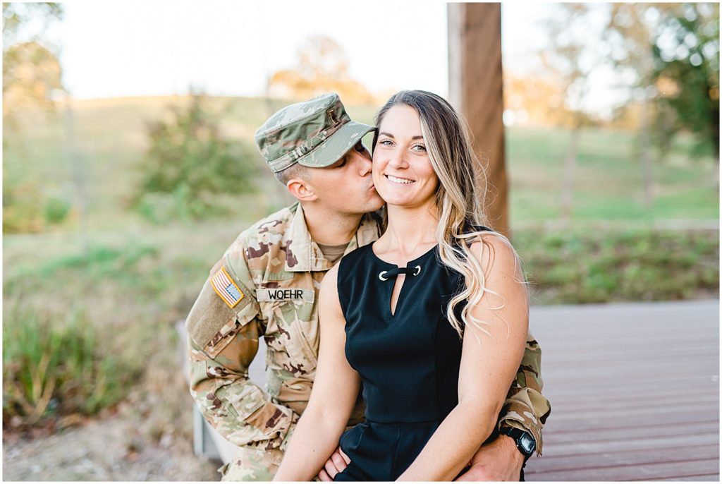 man in army attire kisses wife during photos in Hermann, mo