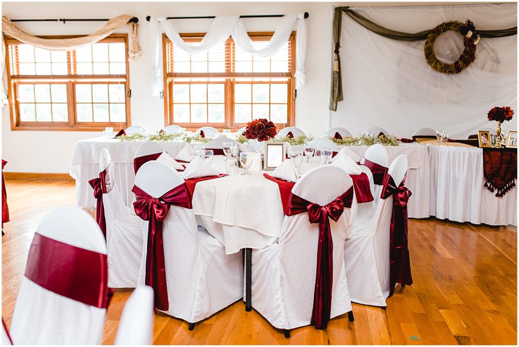 wedding reception details in event room at Canterbury hill winery with maroon chair sashes
