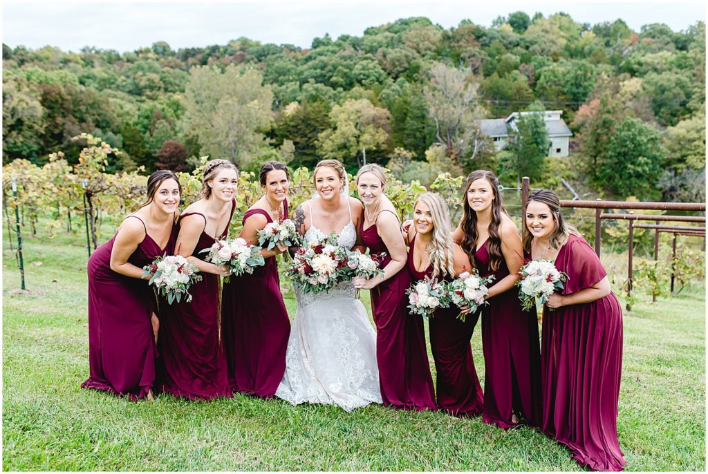 bride and bridesmaids smile at the camera during wedding party portraits at Canterbury hill winery
