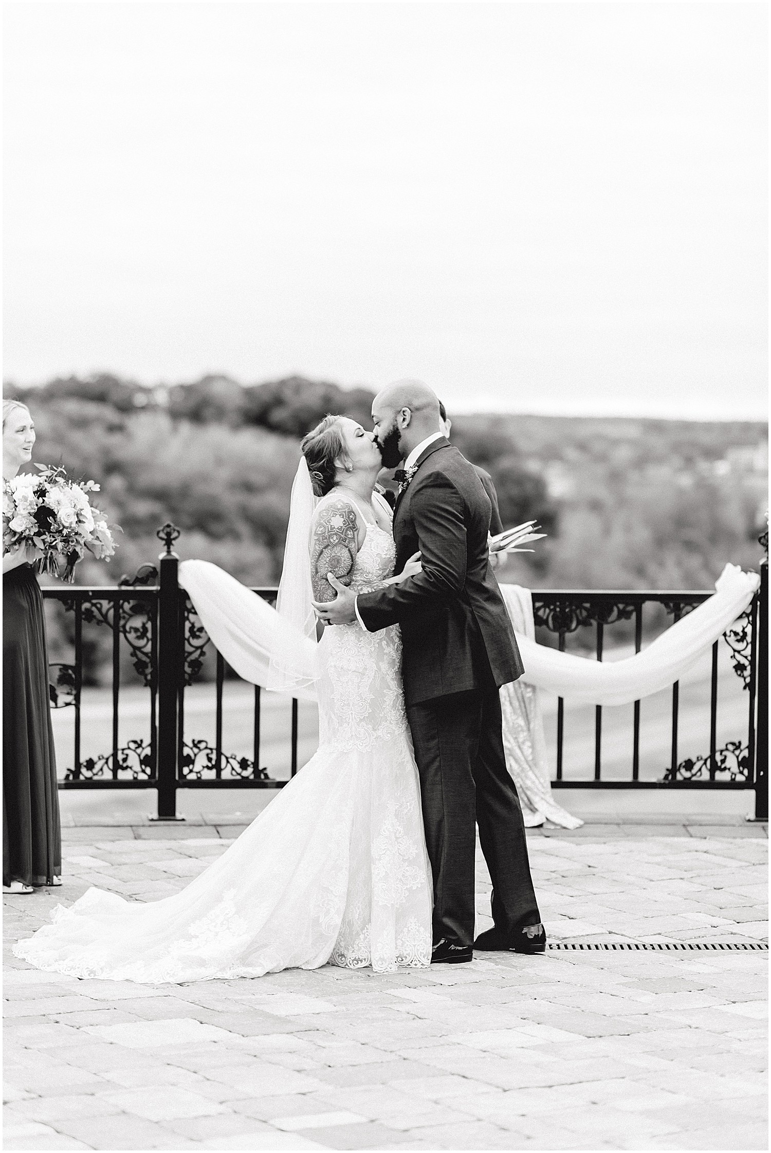 black and white image of bride and groom first kiss on patio at Canterbury hill winery