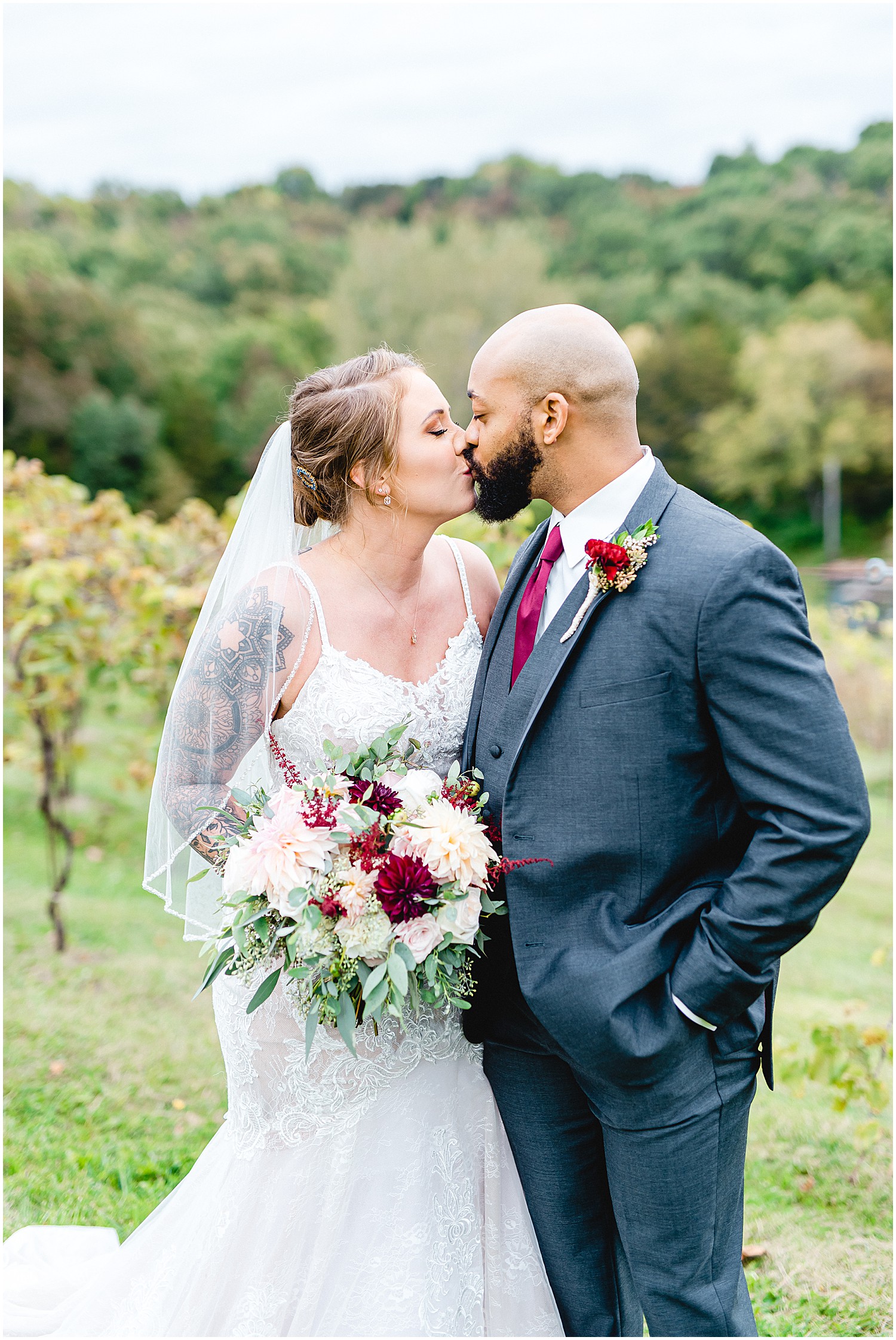 bride and groom kiss during portraits in vineyard at Canterbury hill winery