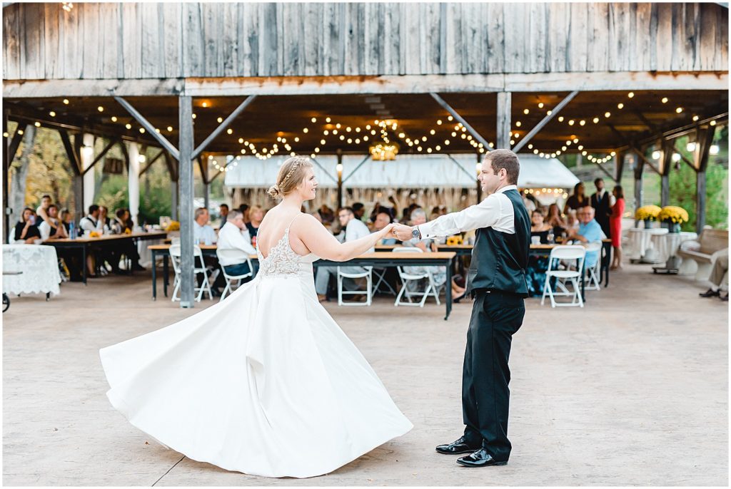 bride and groom dancing and spinning on patio for first dance at wedding reception