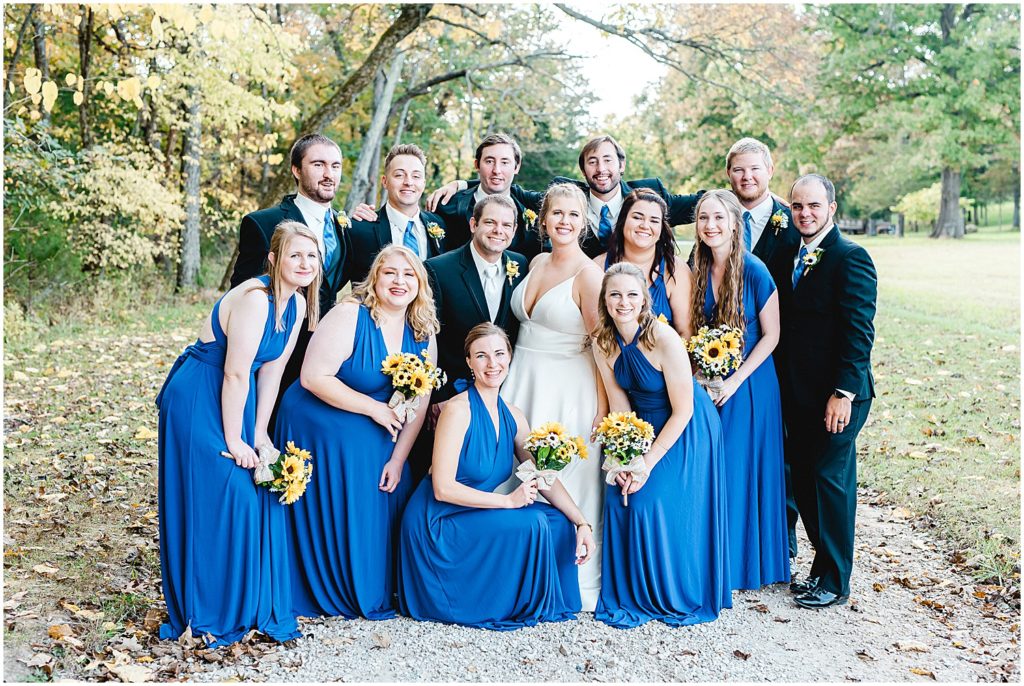 bridal party grouped together smiling at the camera during pictures after wedding ceremony