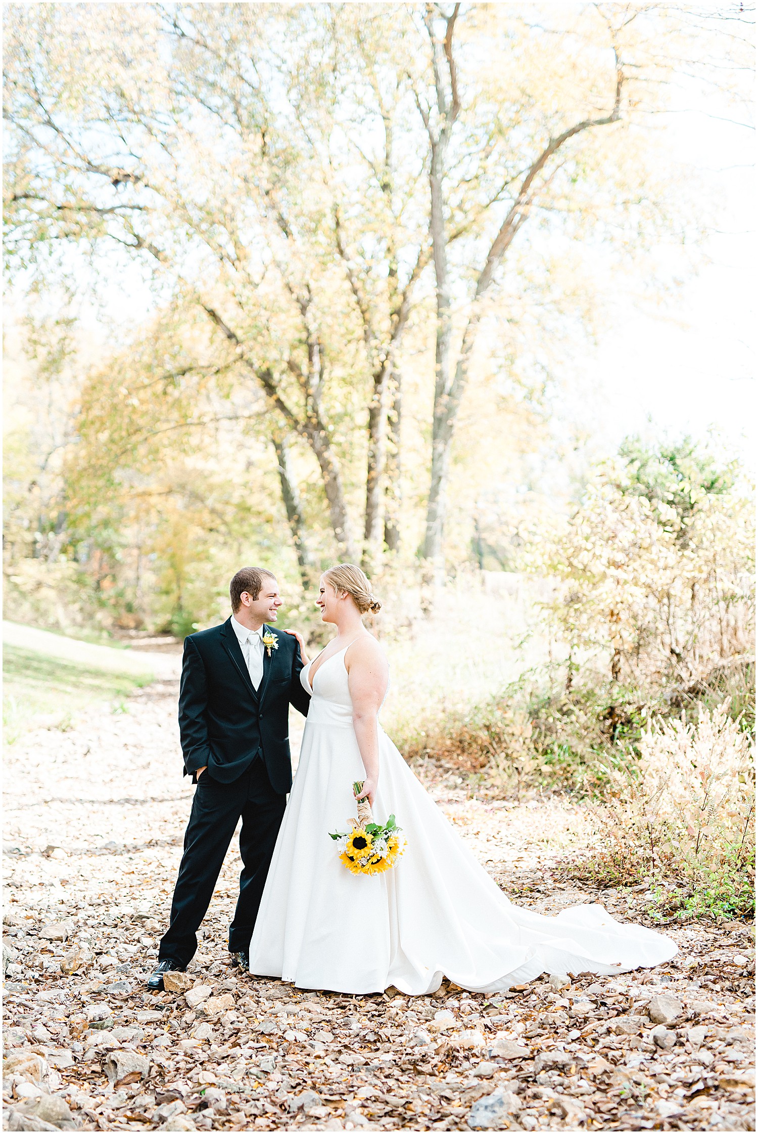 bride and groom smile at each other in the creek bed at kempker's back 40 wedding venue