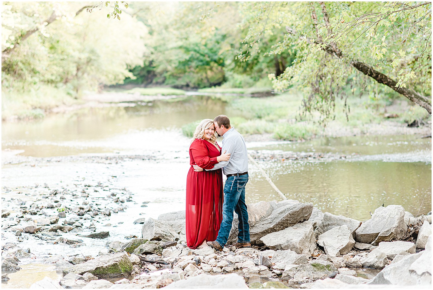 couple standing in creek bed kissing for engagement session