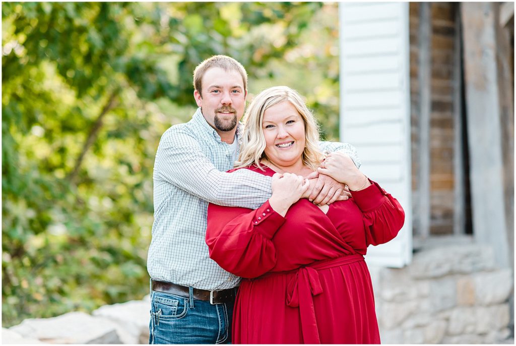 Couple hugging and smiling at camera during engagement photos