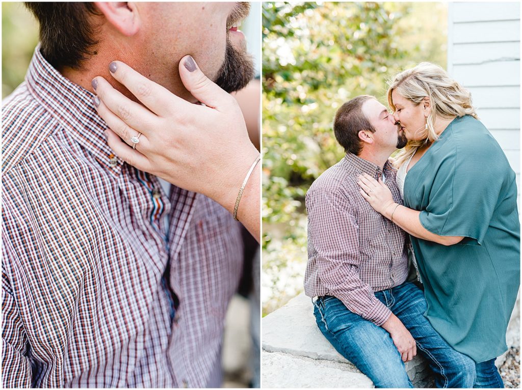 Couple sits on a wall kissing during engagement pictures