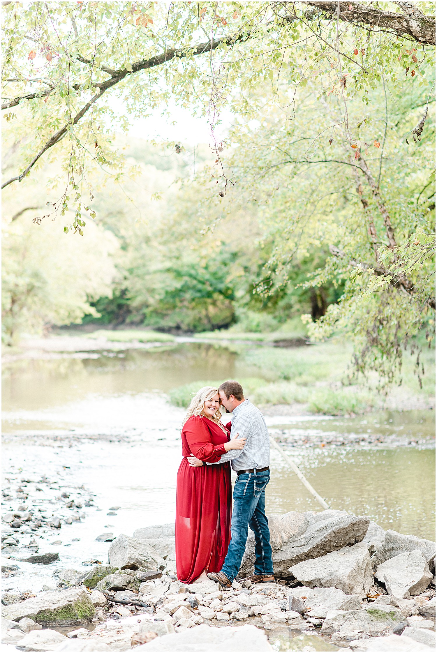 Couple poses in creek bed during missouri engagement session