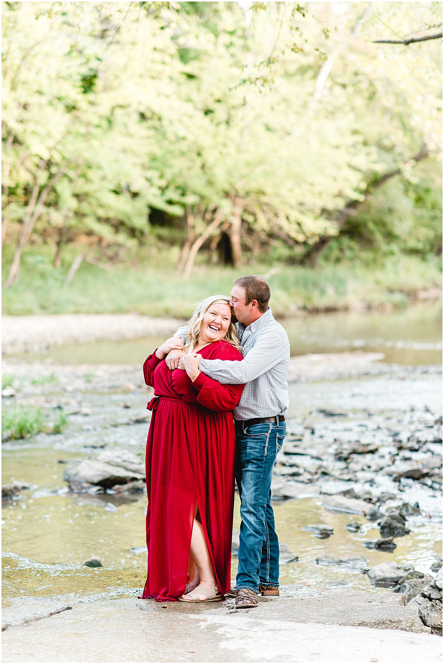 Couple smiles while standing in creek bed for Missouri engagement session