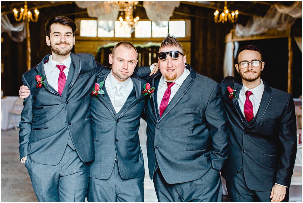 groom and groomsmen smiling at camera before wedding day