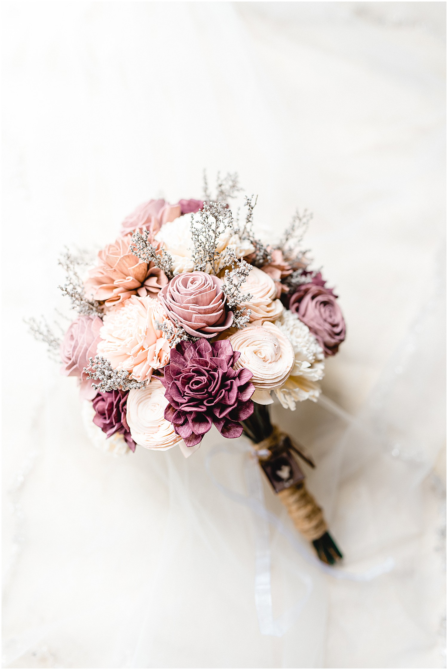 artificial flower bouquet of purple, white, and pink flowers on a white backdrop