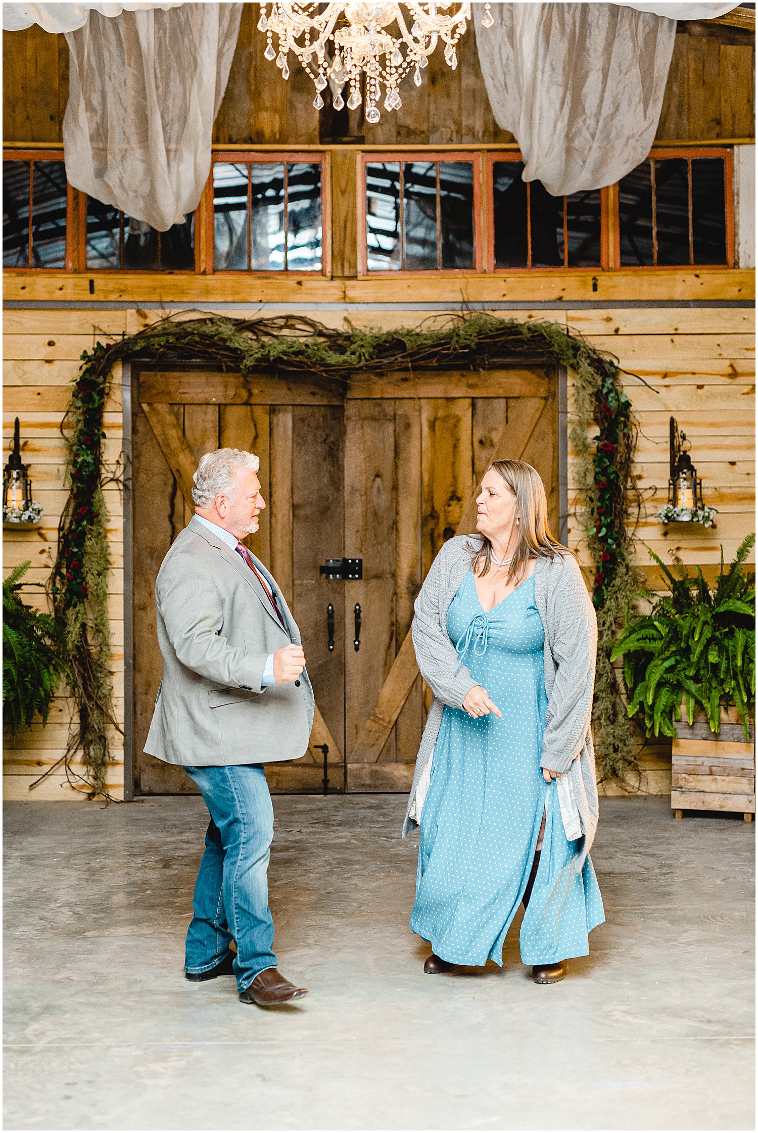 parents of the bride dance during wedding reception in barn