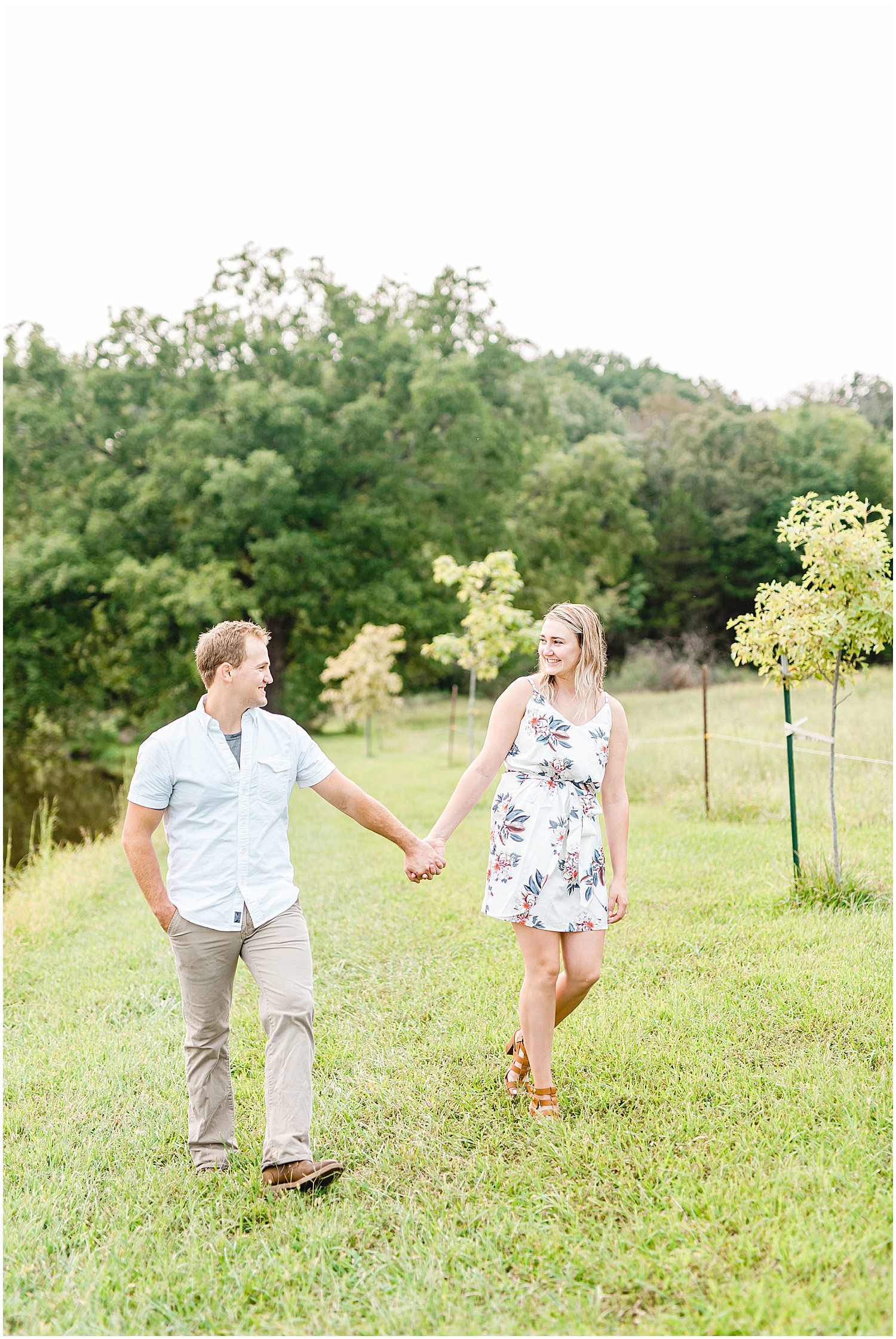 couple walks and smiles at each other during engagement session in missouri
