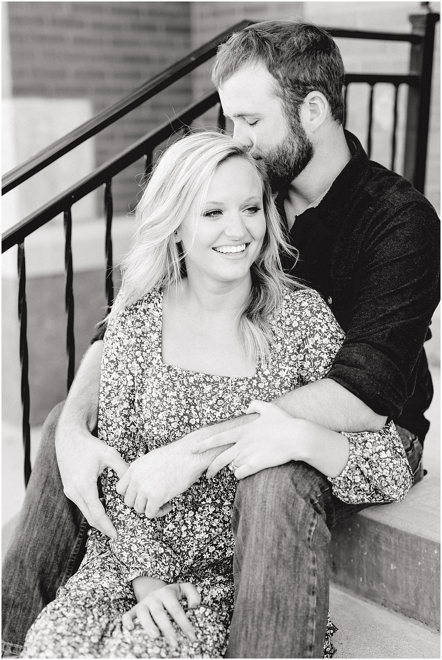 black and white image of couple snuggling on stairs during missouri engagement session