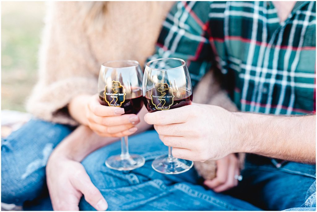 couple toasts with wine glasses during missouri farm engagement session