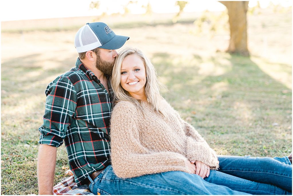 couple sits together on blanket for engagement pictures
