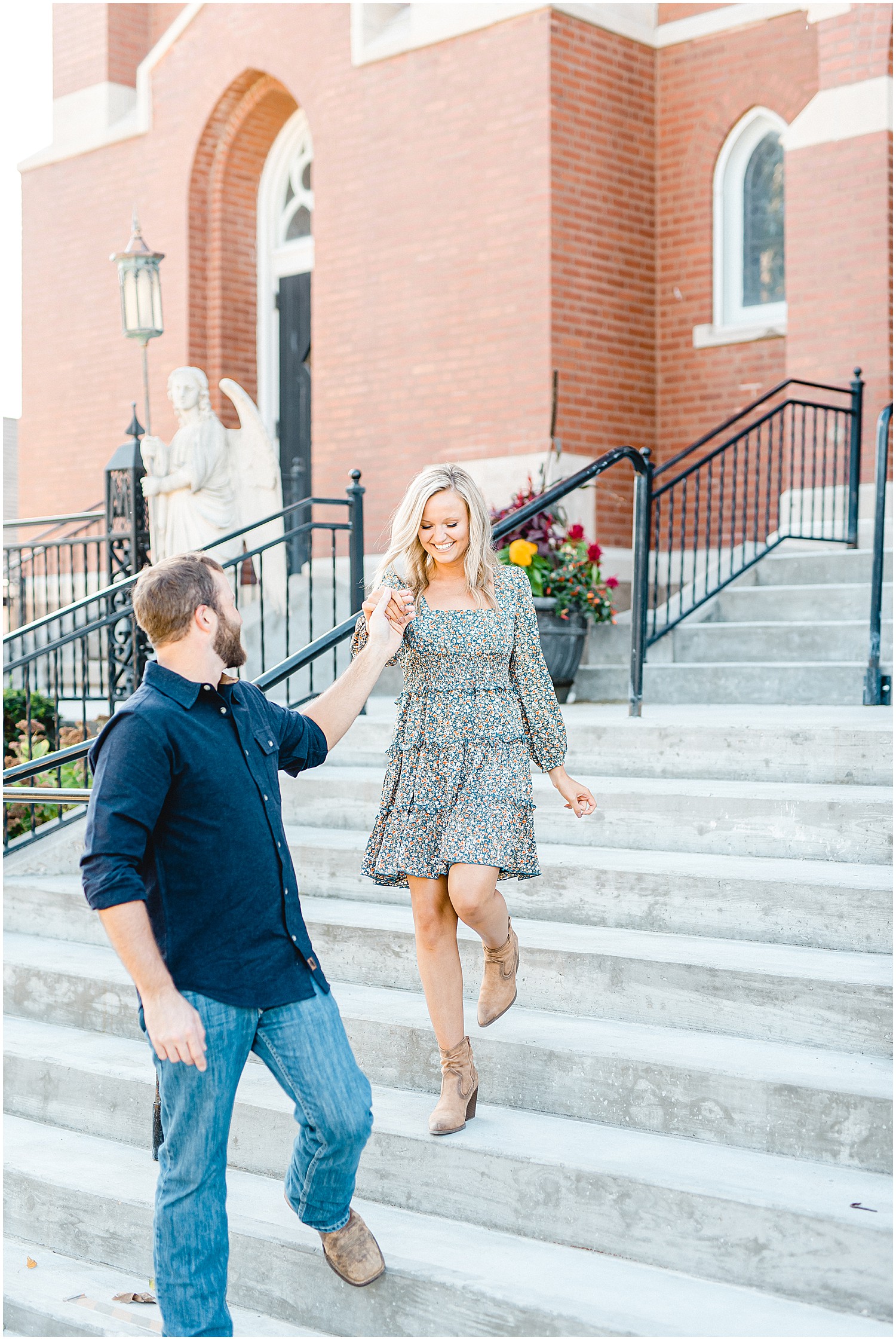 man leads fiancé down church stairs during engagement session