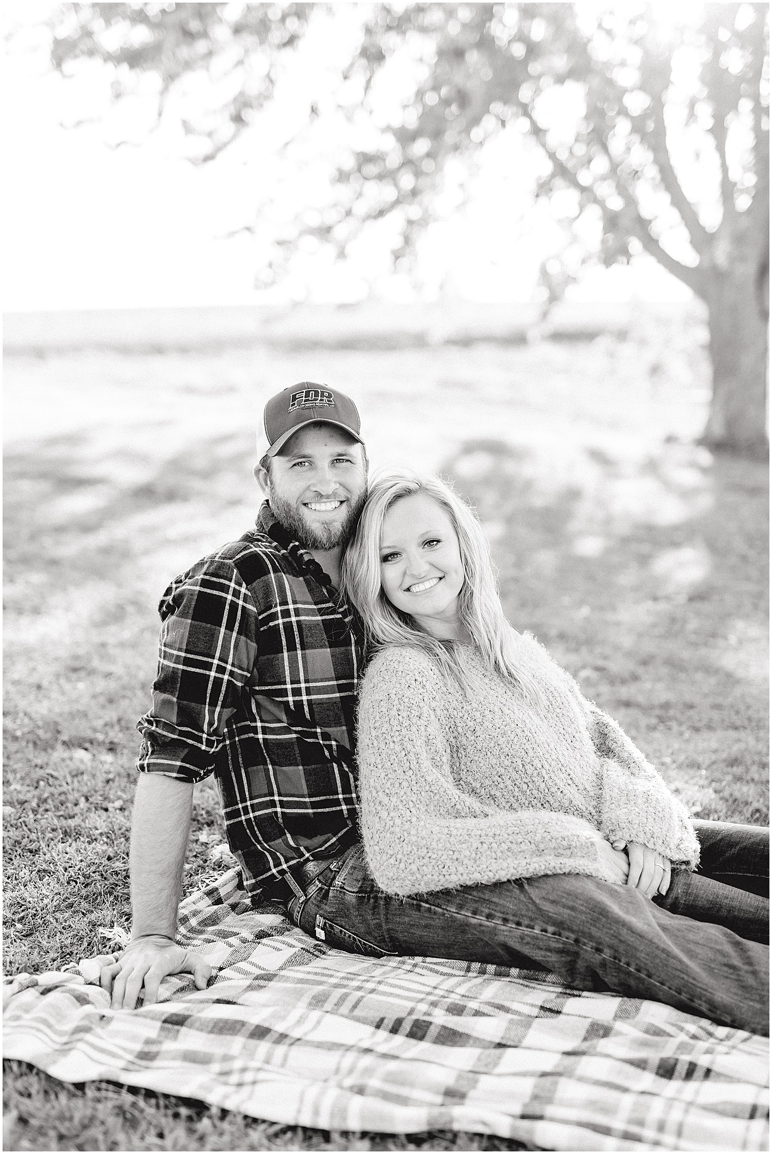 black and white image of couple lounging on picnic blanket during missouri engagement pictures