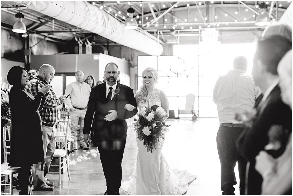 black and white image of bride and dad walking down the aisle