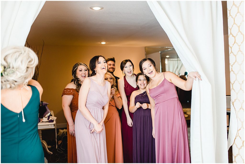 bridesmaids seeing bride for the first time through curtain
