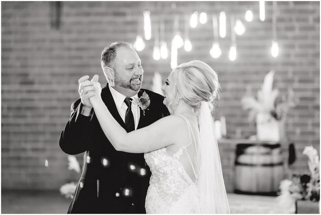 black and white image of bride and father dancing during wedding reception