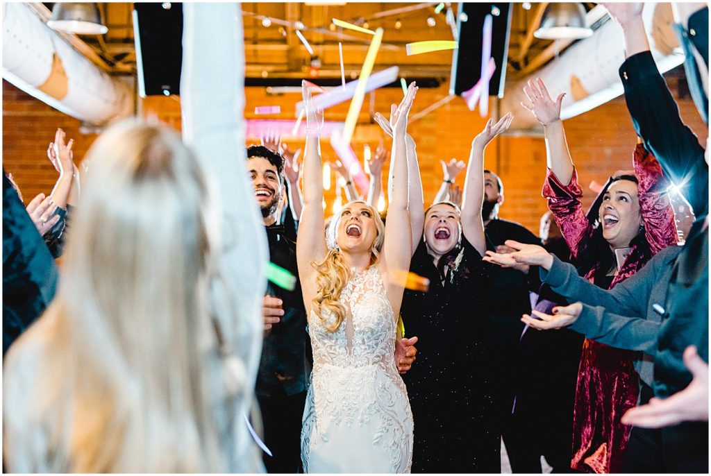wedding guests throw glow sticks in the air after wedding reception