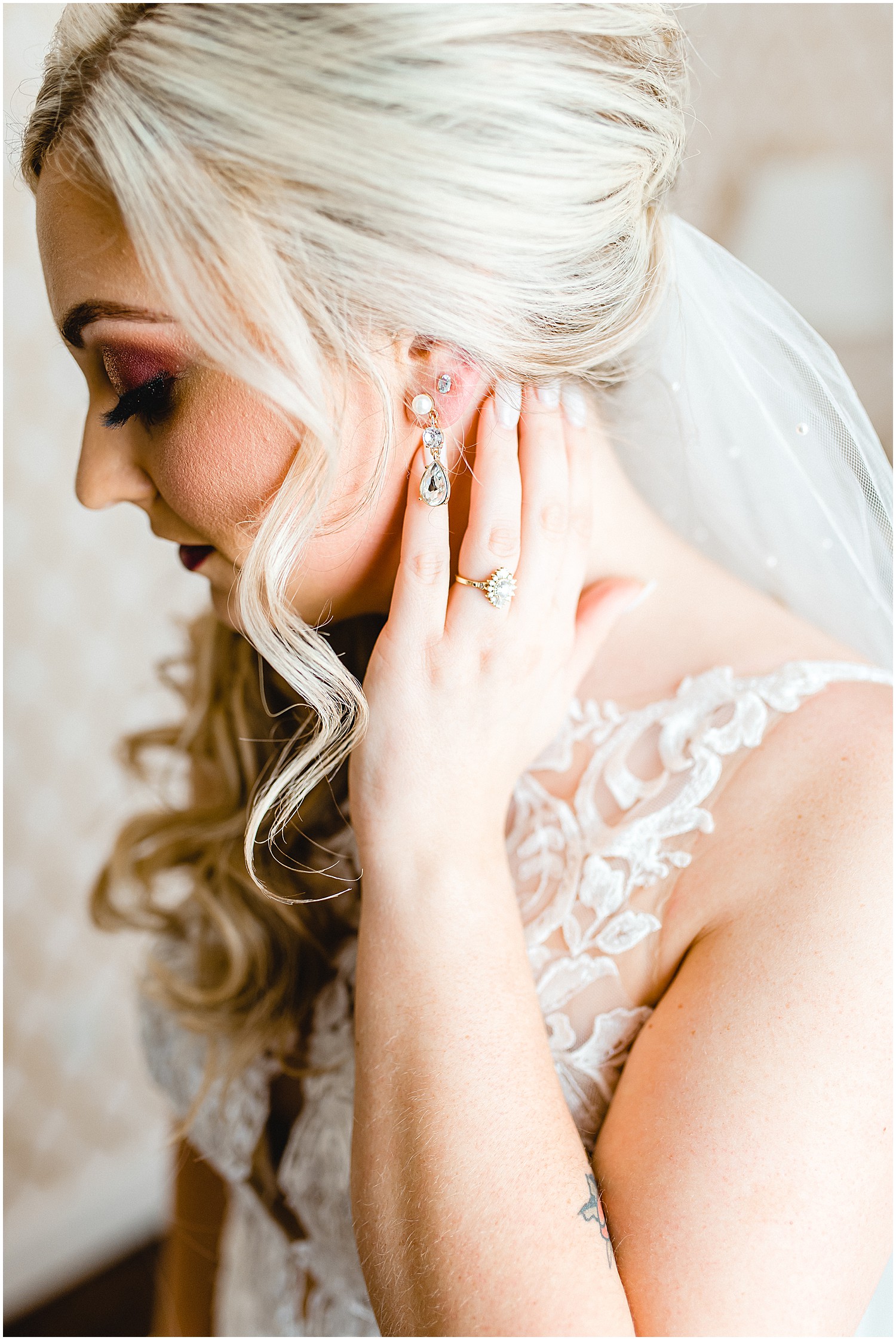 bride touches neck with rings and earrings showing
