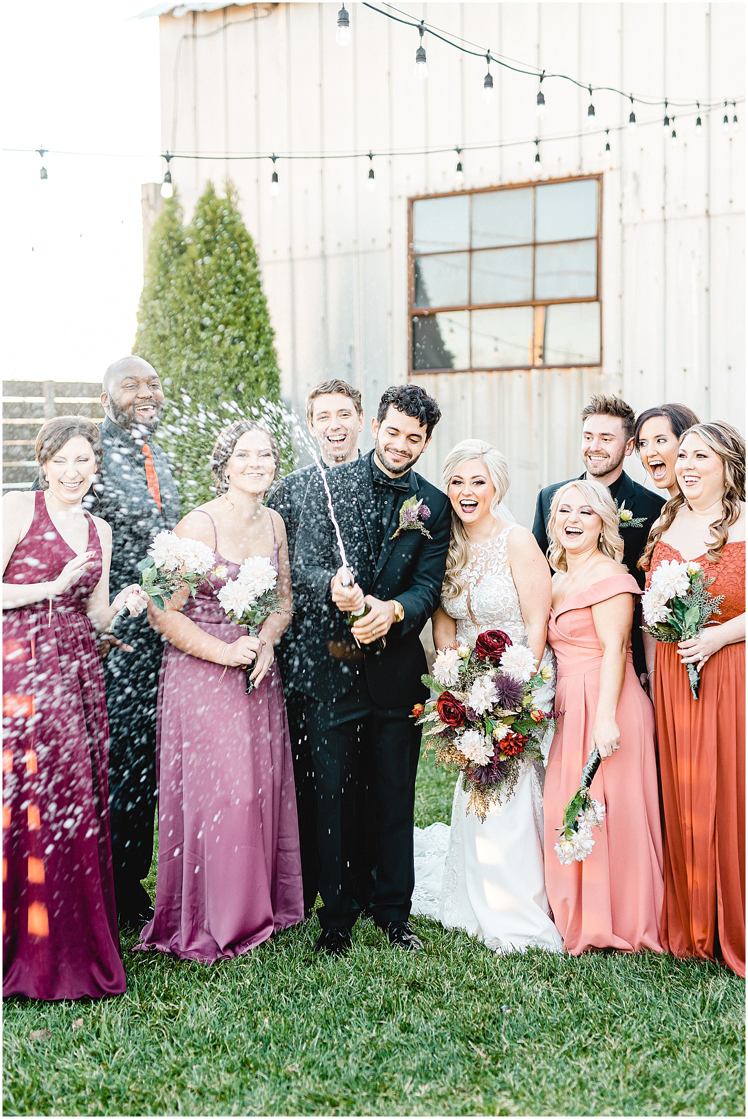 groom pops champagne during wedding party portraits
