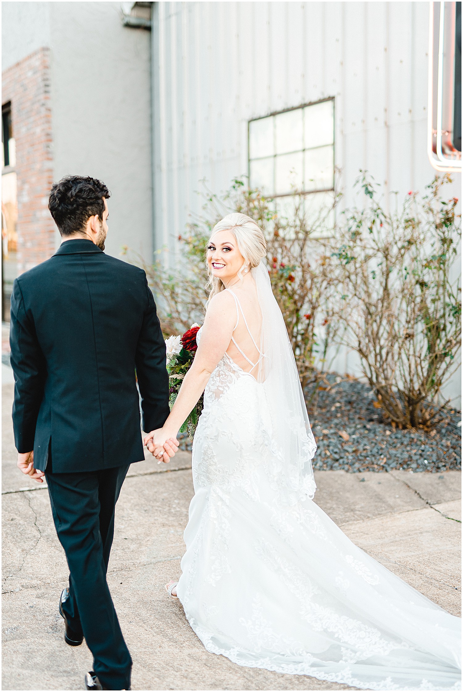 bride and groom walk away and smile during portraits on wedding day
