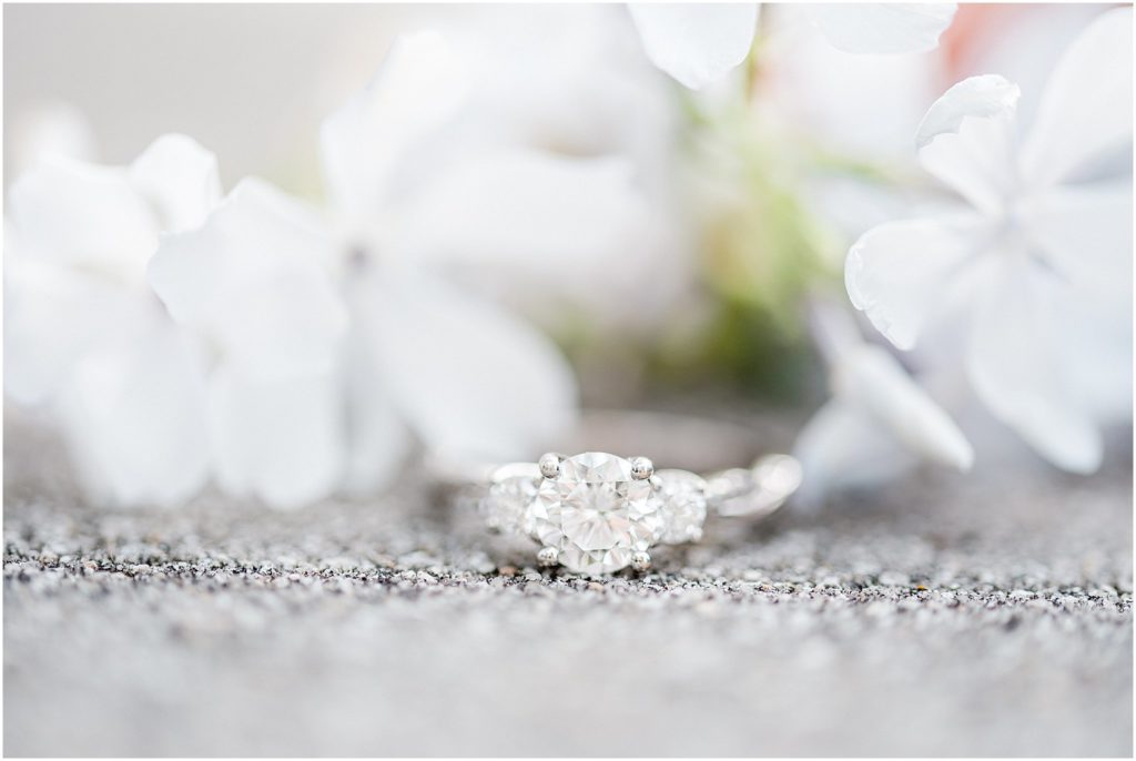 up close shot of engagement ring with white flowers