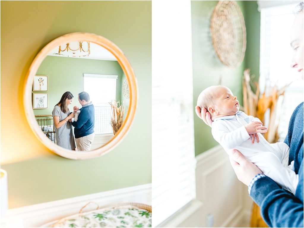 mom and dad hold newborn baby standing in mirror