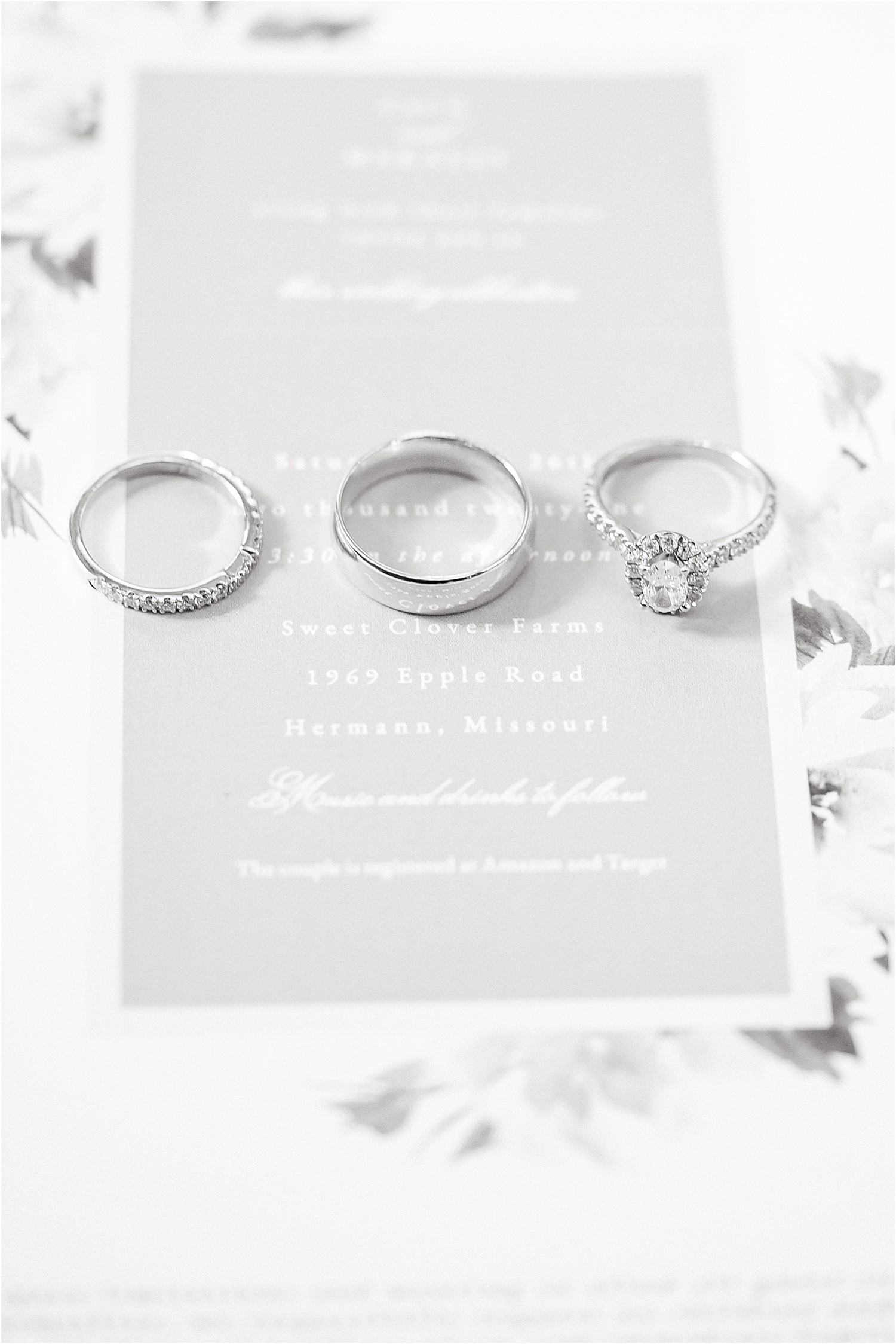 black and white image of three wedding rings on a wedding invitation