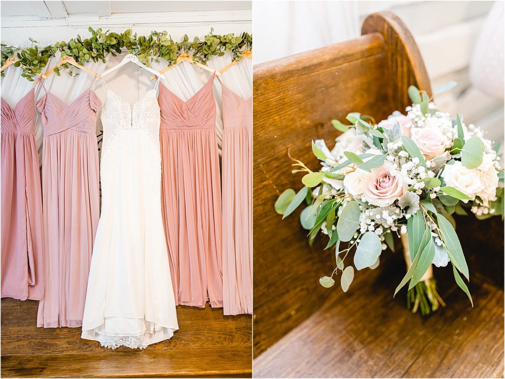pink bridesmaids dresses hang next to wedding gown and white and pink bouquet sits on a bench