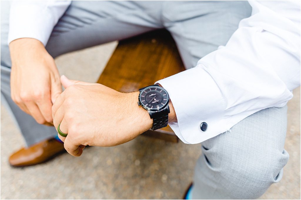 image of groom watch while sitting on bench
