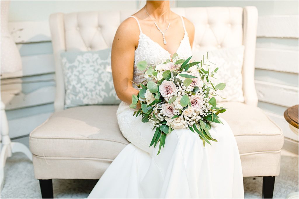 bride sits with bouquet on lap 