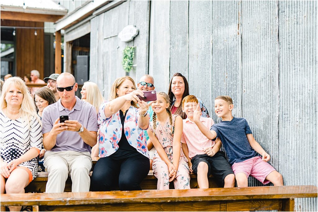 wedding guests take a selfie during wedding ceremony